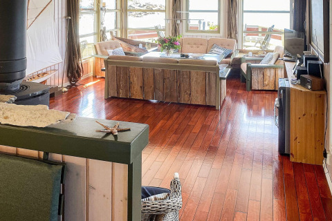 Luminoso salón en la casa flotante 38508-FISKHOLMEN en Dinamarca, con suelos de madera y decoración rústica.