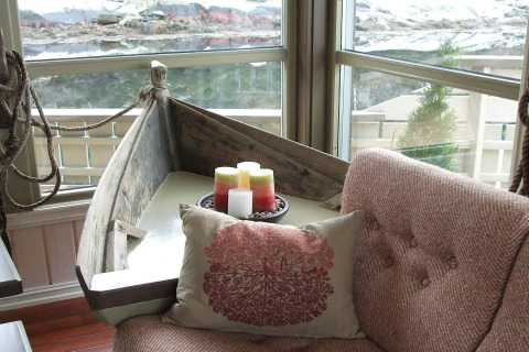 Sala de estar acogedora en la casa flotante 38508-FISKHOLMEN en Dinamarca, con mesa-barco y velas.