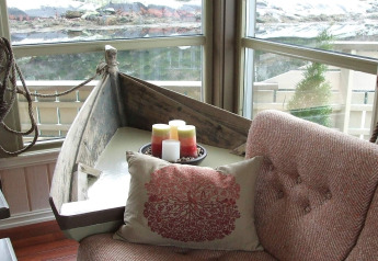 Gezellige woonkamer op woonboot 38508-FISKHOLMEN in Denemarken, met een boottafel en kaarsen.