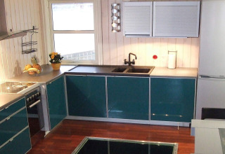 Moderne keuken op woonboot 38508-FISKHOLMEN in Denemarken met groene kasten, spoelbak en raam.