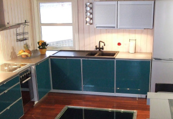 Moderne keuken op woonboot 38508-FISKHOLMEN in Denemarken met groene kasten, spoelbak en raam.