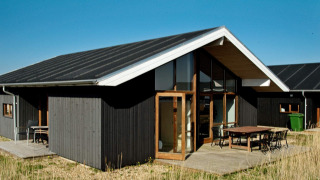 Chalet moderne pour 8 personnes à Ulfborg, façade en bois, terrasse spacieuse et design contemporain.