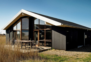 Chalet de vacances moderne pour 8 personnes à Ulfborg, Danemark, avec grandes baies et façade noire.
