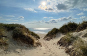 Vue sur une plage ensoleillée à Ulfborg, Danemark, à travers les dunes depuis le chalet de vacances.