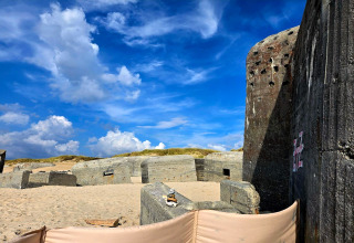 Vecchi bunker di cemento su una spiaggia sabbiosa con cielo blu a Ulfborg, Danimarca, vista vacanza.