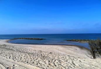 Vue sur la plage depuis le "gîte 8 personnes à Ulfborg" au Danemark, vue sur sable, mer et ciel bleu.