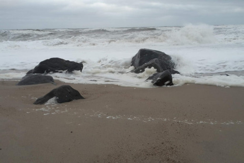 Golven die breken op rotsen bij het strand aan een 8-persoons vakantiehuis in Ulfborg, Denemarken.