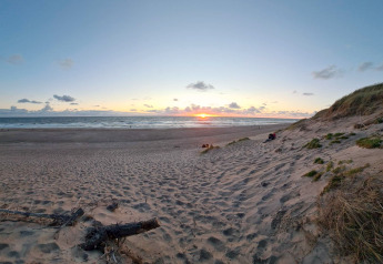 Coucher de soleil vu d’une dune près de la plage, proche du chalet 8 personnes à Ulfborg, Danemark.