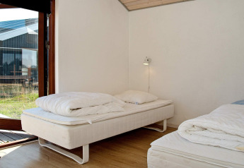 Dormitorio en casa de vacaciones para 8 personas en Ulfborg, Dinamarca, con dos camas y acceso a la terraza.