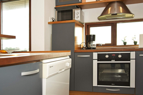 Modern kitchen in a holiday chalet in Ulfborg, Denmark, with oven, dishwasher and coffee maker.