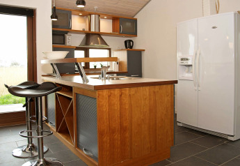 Cuisine moderne dans une maison de vacances à Ulfborg, Danemark, avec îlot, tabourets et grand frigo.