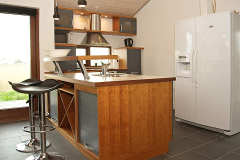 Cuisine moderne dans une maison de vacances à Ulfborg, Danemark, avec îlot, tabourets et grand frigo.