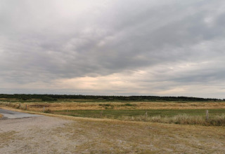 Landschapszicht vanaf het 6-persoons vakantiehuis in Hadsund, Denemarken, onder een bewolkte hemel.