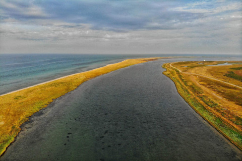 Aerial view of a narrow strip of land with water on both sides at Hadsund, Denmark, on a cloudy day.