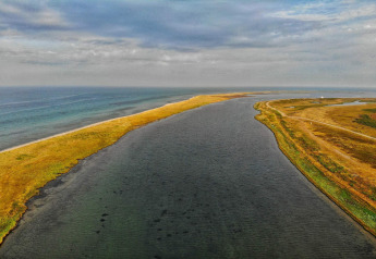 Luchtbeeld van een smalle landstrook met water aan beide zijden bij Hadsund, Denemarken, op een bewolkte dag.