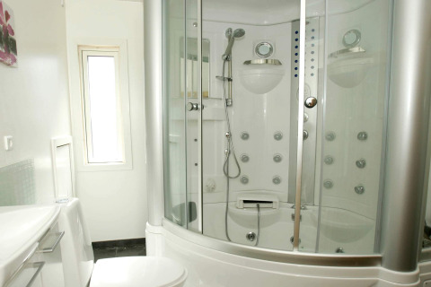 Modern bathroom with luxury shower cabin and toilet at a 6 person holiday home in Hadsund, Denmark.