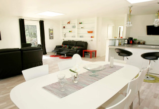 Heldere, moderne woonkamer en keuken met eethoek in vakantiehuis voor 6 personen in Hadsund, Denemarken.