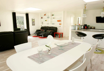 Lichte, moderne woonkamer en keuken met eethoek in 6-persoons vakantiehuis in Hadsund, Denemarken.