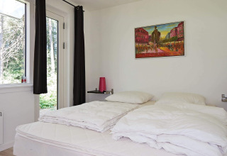 Dormitorio luminoso en casa de vacaciones en Hadsund, Dinamarca, con arte en la pared y vista a la naturaleza.