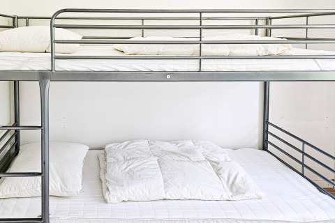 Lit superposé moderne en métal avec draps blancs dans une maison de vacances pour 6 personnes à Hadsund, Danemark.