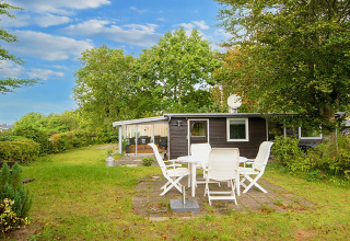 Buitenaanzicht van vakantiehuis voor 4 personen in Allingåbro, Denemarken, met gras en tuinset.