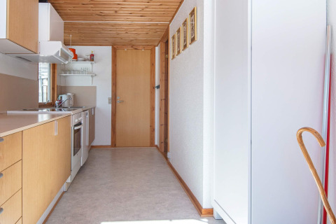 Cocina estrecha y luminosa con gabinetes de madera clara en una casa de vacaciones en Allingåbro, Dinamarca.
