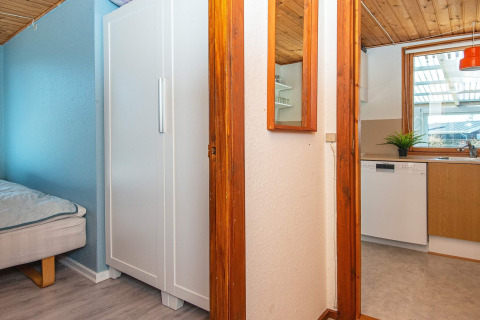Vista interior de una casa de vacaciones en Allingåbro, Dinamarca, con dormitorio, armario y cocina.
