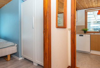 Vista interior de una casa de vacaciones en Allingåbro, Dinamarca, con dormitorio, armario y cocina.