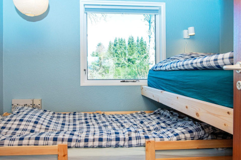 Habitación con literas y ropa de cama a cuadros en casa de vacaciones para 4 personas en Allingåbro, Dinamarca.