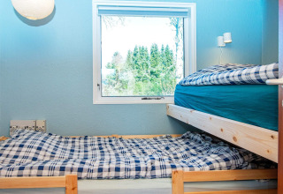 Habitación con literas y ropa de cama a cuadros en casa de vacaciones para 4 personas en Allingåbro, Dinamarca.