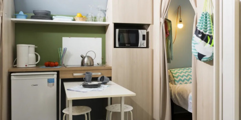 Binnenkant van een Coco Suite safaritent bij Weekend Glamping Resort in Italië met keuken en bed.
