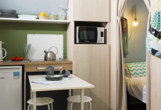 Binnenkant van een Coco Suite safaritent bij Weekend Glamping Resort in Italië met keuken en bed.