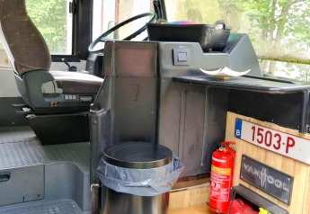 Interieur van mobilhome REEBUS in België met bestuurdersstoel, prullenbak en brandblusser.