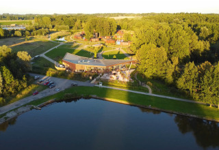 Aerial view of The TreeLoft by YourNature in Belgium, surrounded by forest, water, and open green space.