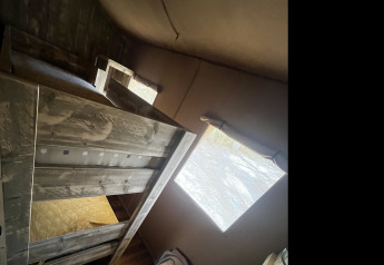 Vue intérieure de la tente safari Lodge « Woody 27 » avec lits superposés au camping Les Franquettes en France.