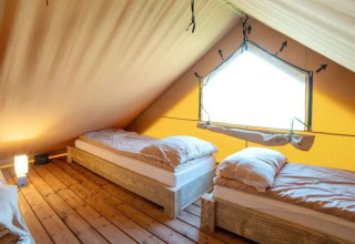 Indretning af en safari telt-lodge med tre enkeltsenge i Weekend Glamping Resort, Italien.