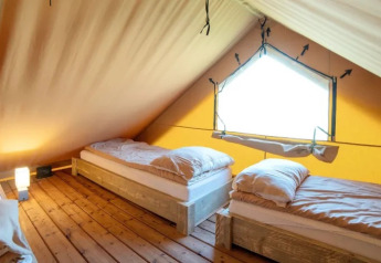 Indretning af en safari telt-lodge med tre enkeltsenge i Weekend Glamping Resort, Italien.