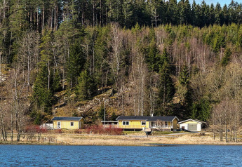 Gezellige gele chalet voor 4 personen aan het meer in Hällevadsholm, Zweden, omringd door bos.