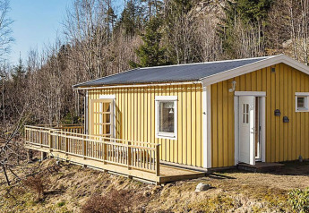 Gele houten vakantiewoning met terras voor 4 personen in Hällevadsholm, omringd door natuur.