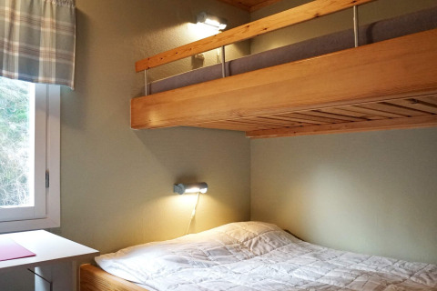 Knusse slaapkamer met stapelbedden en raam in een 4-persoons vakantiehuis in Hällevadsholm, Zweden.