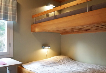 Gemütliches Schlafzimmer mit Etagenbett und Fenster in einem 4-Personen-Ferienhaus in Hällevadsholm, Schweden.