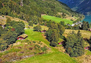 Luftfoto af 6-personers feriehus i Olden, Danmark, omgivet af bakker, træer og grønne marker.