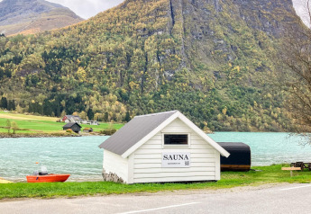 Sauna bianca sul lago turchese con montagne, vicino a casa vacanze per 6 persone a Olden, Danimarca.