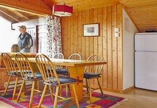 Spisestue i træindrettet chalet, 6-personers feriehus i Olden, Danmark, med spisebord og stole.