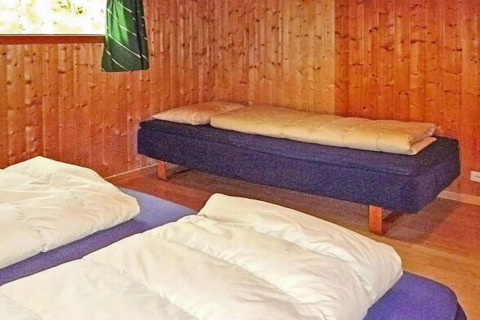 Slaapkamer in 6-persoons vakantiehuis in Olden, Denemarken, met drie bedden en houten wanden.