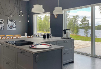 Moderne keuken in een ruime lodge met uitzicht op het meer in Zweden, grote ramen en kunst aan de muur.