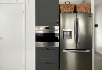 Cocina moderna en Spacious Lakeside Villa con nevera de acero, horno y cestas en Suecia.