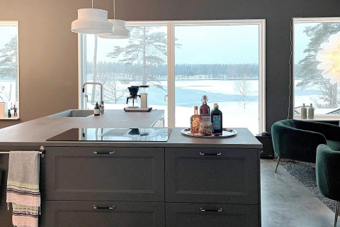 Cucina moderna in una villa spaziosa con grandi finestre e vista su un lago innevato in Svezia.