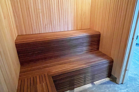 Vista interna di una sauna moderna in legno con panche in una spaziosa villa sul lago in Svezia.