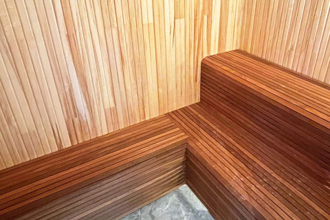 Coin intérieur d’un sauna en bois avec bancs, situé dans une spacieuse villa au bord d’un lac en Suède.